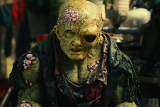 Toxie looking suspiciously while sitting in a junkyard in toxic avenger 2025.jpg