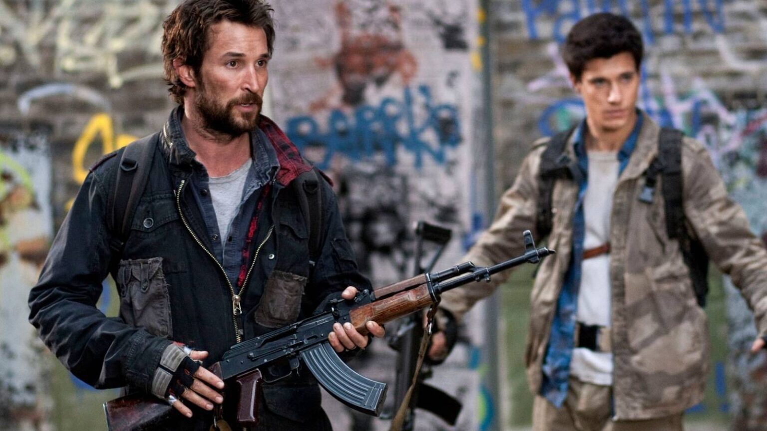 Tom mason holding an assault rifle with hal mason holding his hands up in the background in falling.jpeg