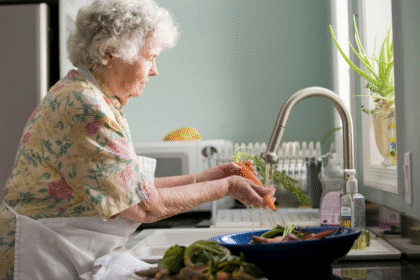 Elderly woman preparing vegetables in the kitchen.png