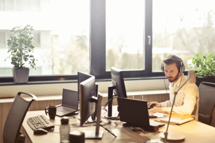 Man with headphones facing computer monitor.png