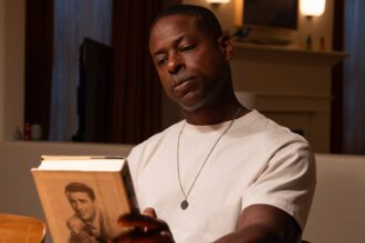 Xavier sitting in the kitchen while looking at a book in paradise season 1.jpg