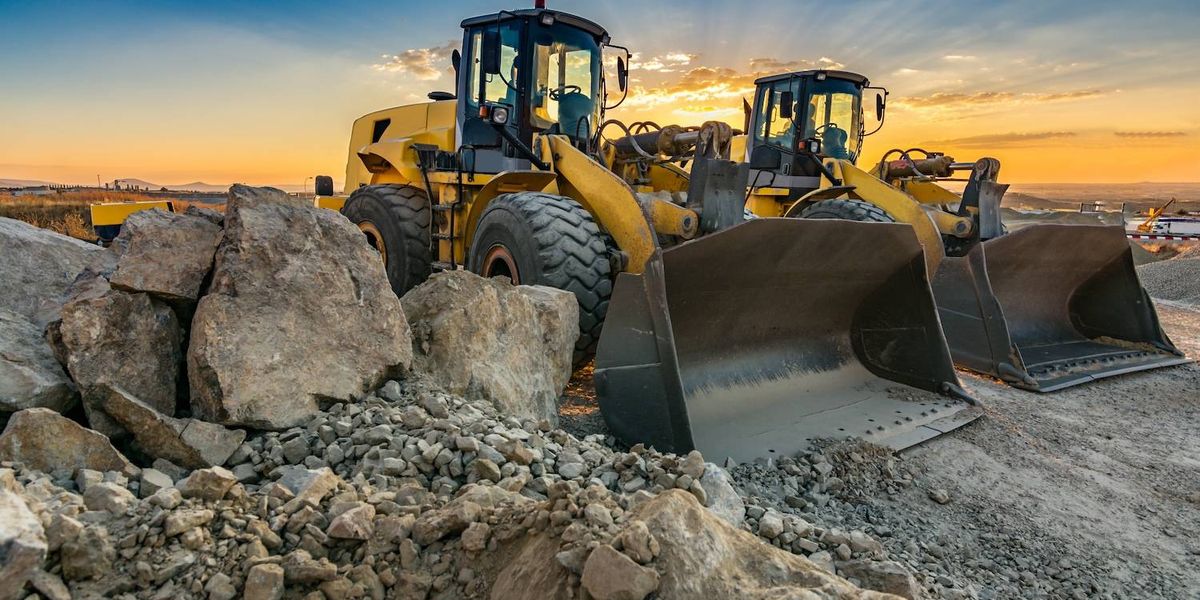 Two bulldozers at a construction site during sunset.jpg