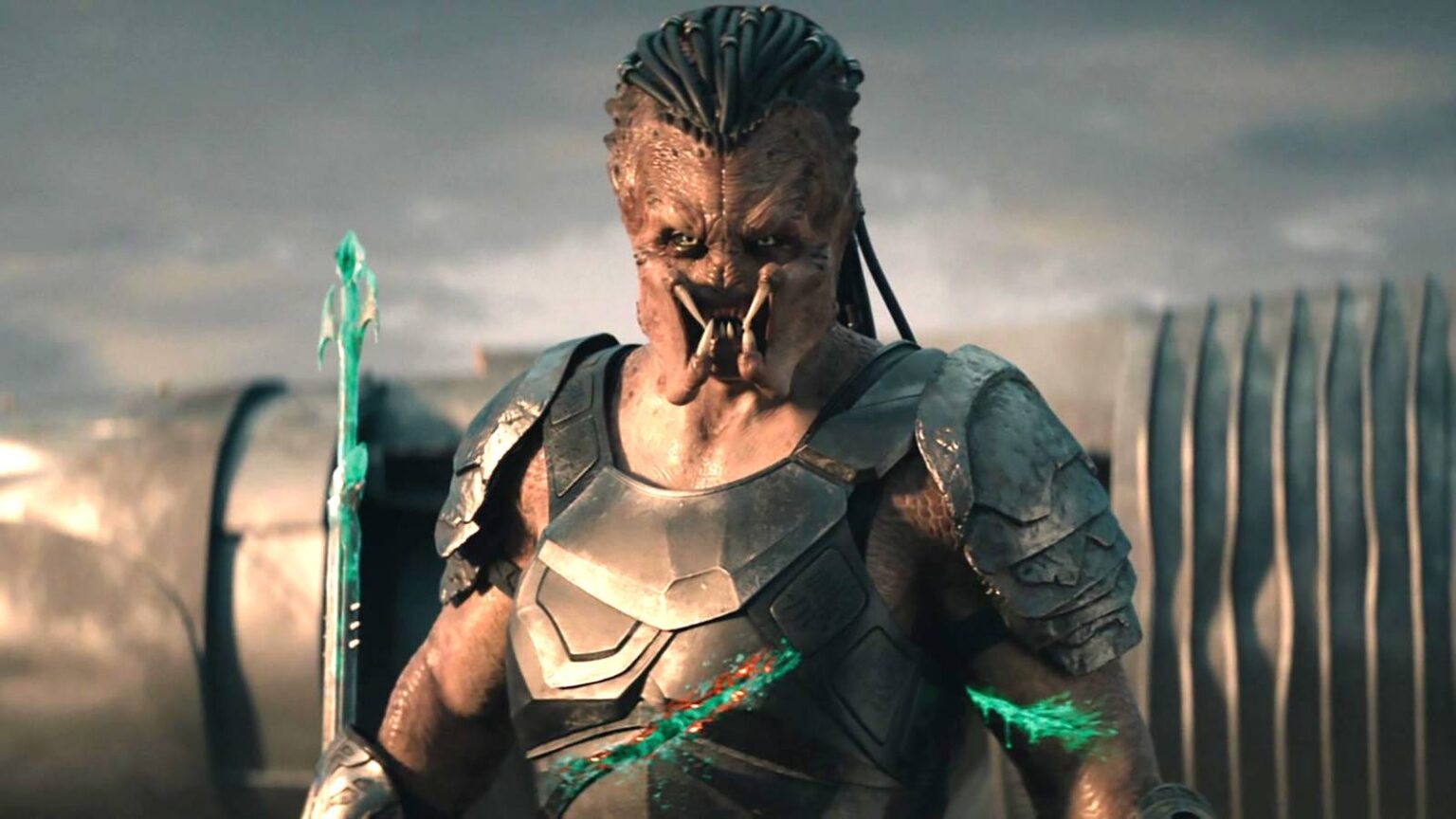 Dek looking intensely while holding a spear with blood on it and having multiple cuts in predator ba.jpeg