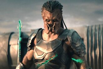 Dek looking intensely while holding a spear with blood on it and having multiple cuts in predator ba.jpeg