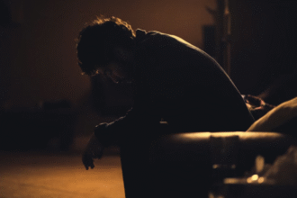 Silhouette of stressed man sitting in dark.png