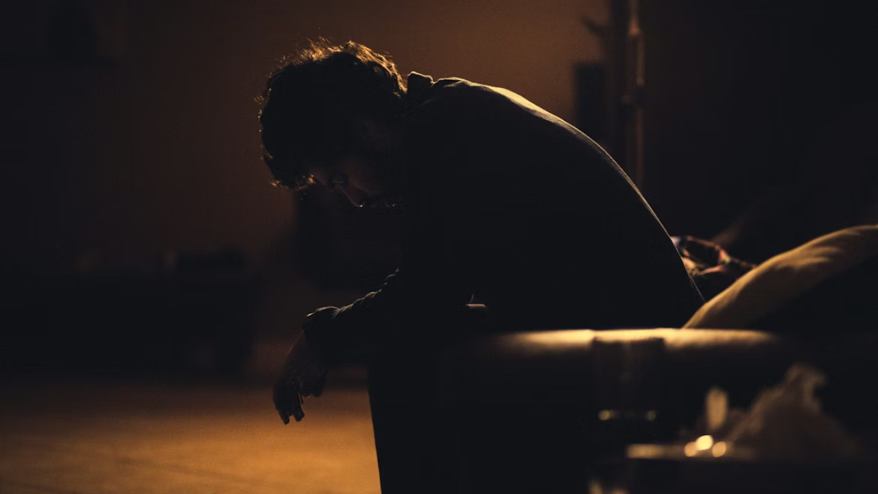 Silhouette of stressed man sitting in dark.png