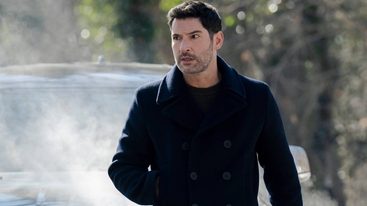 Tom ellis colin looking intense while standing in front of a car in cia.jpg