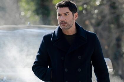 Tom ellis colin looking intense while standing in front of a car in cia.jpg