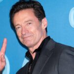 Hugh jackman makes a peace sign at the red carpet of the death of robin hood.jpg