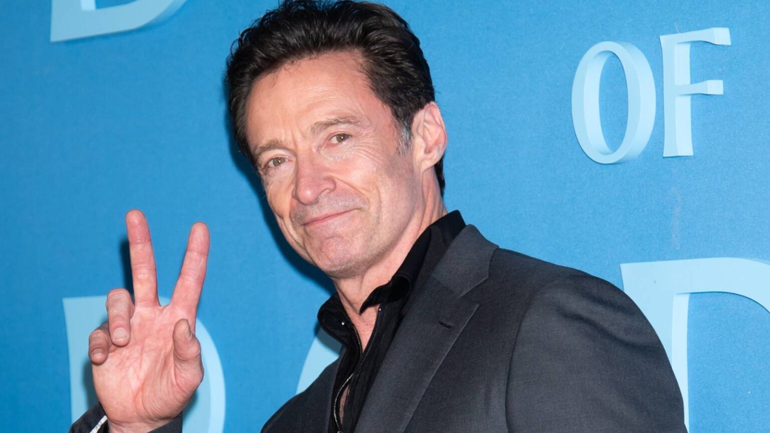 Hugh jackman makes a peace sign at the red carpet of the death of robin hood.jpg